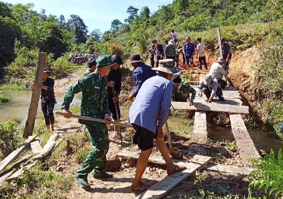 Cán bộ, chiến sĩ Đồn Biên phòng Tri Lễ (Bộ đội Biên phòng Nghệ An) phối hợp với chính quyền địa phương và người dân bản Huồi Mới (xã Tri Lễ, huyện Quế Phong) làm lại cầu dân sinh sau lũ. Ảnh: TTXVN phát nghe-an-4625.jpg