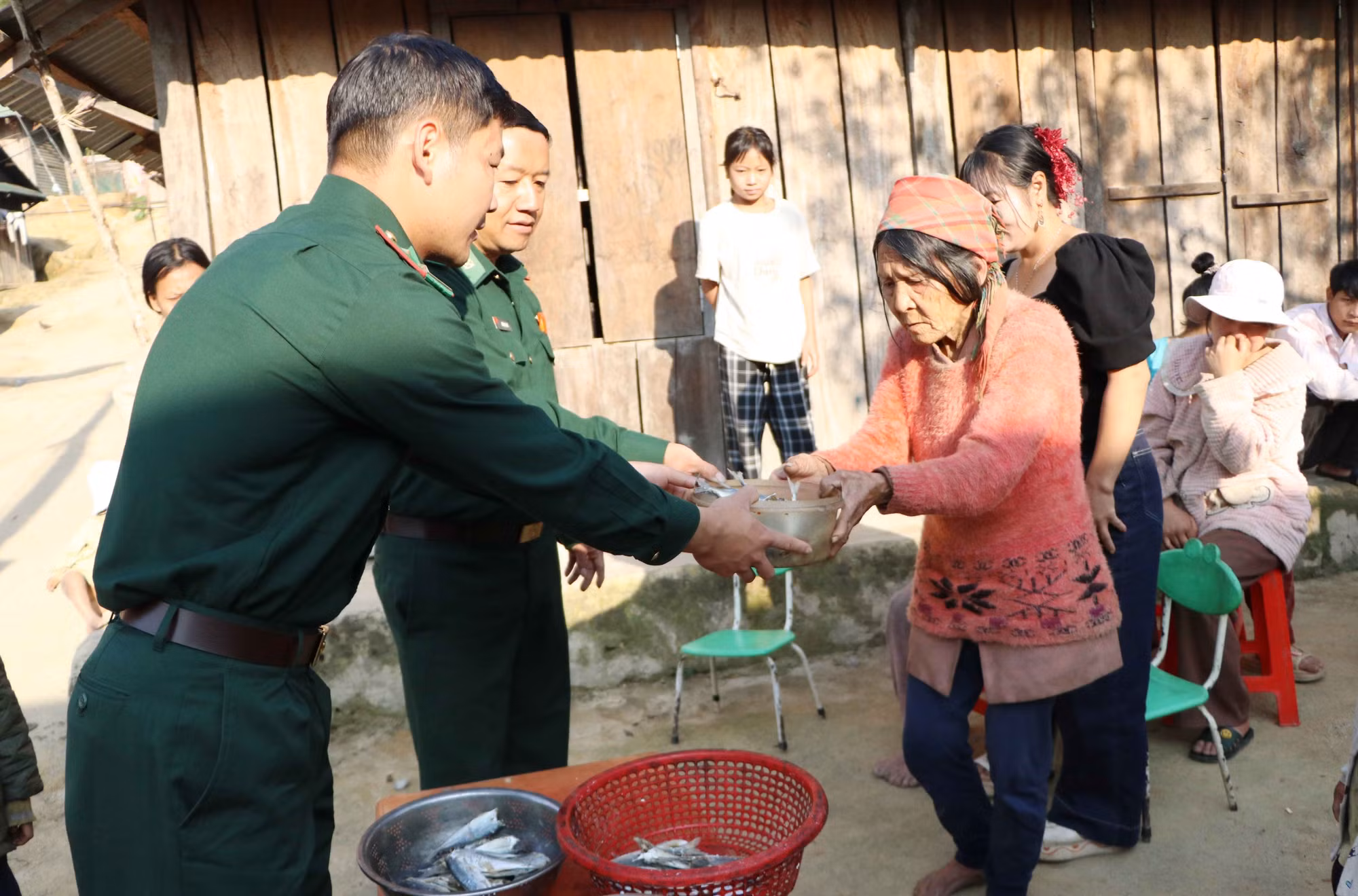 Bộ đội Biên phòng đồn Thu Lũm chia từng con cá khô cho người La Hủ ở bản Là Si, xã Thu Lũm.