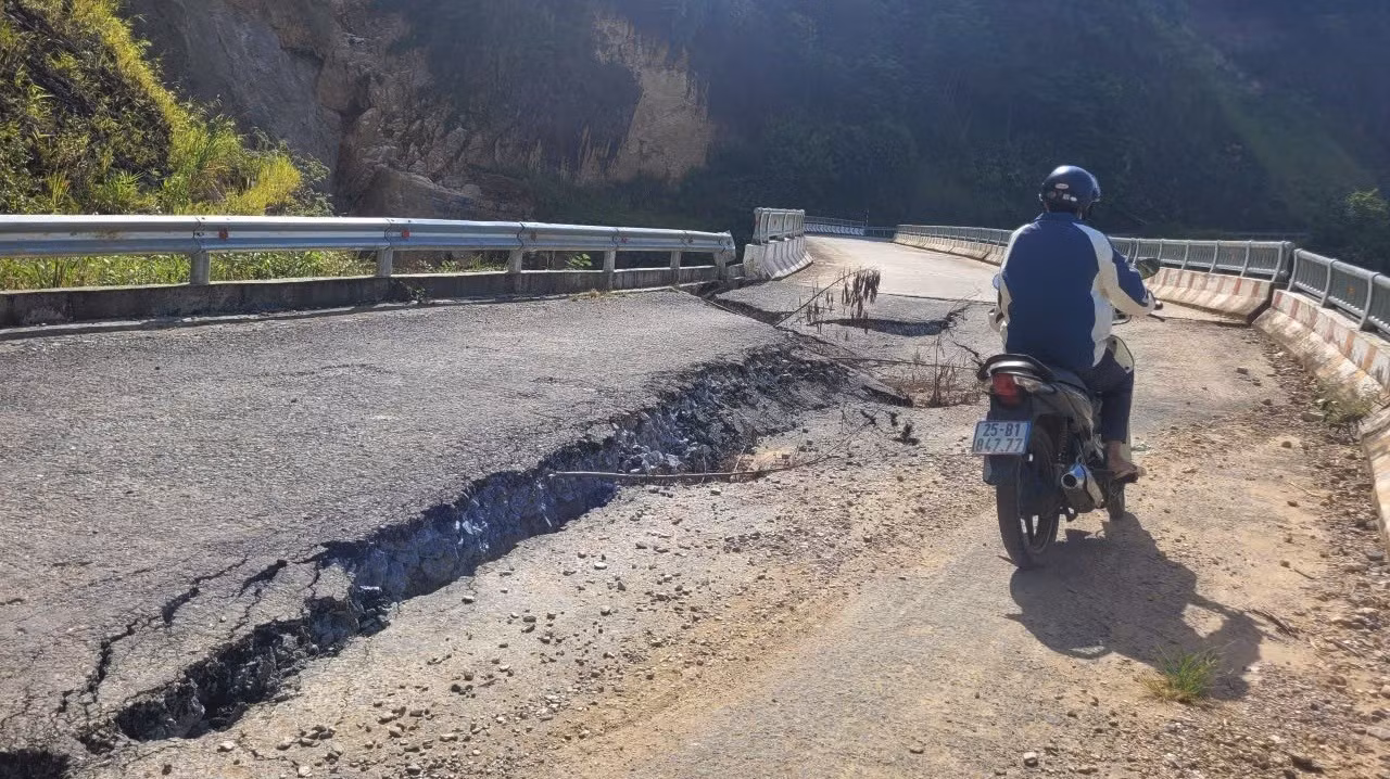 Người dân di chuyển qua những điểm nứt gãy của mặt cầu.