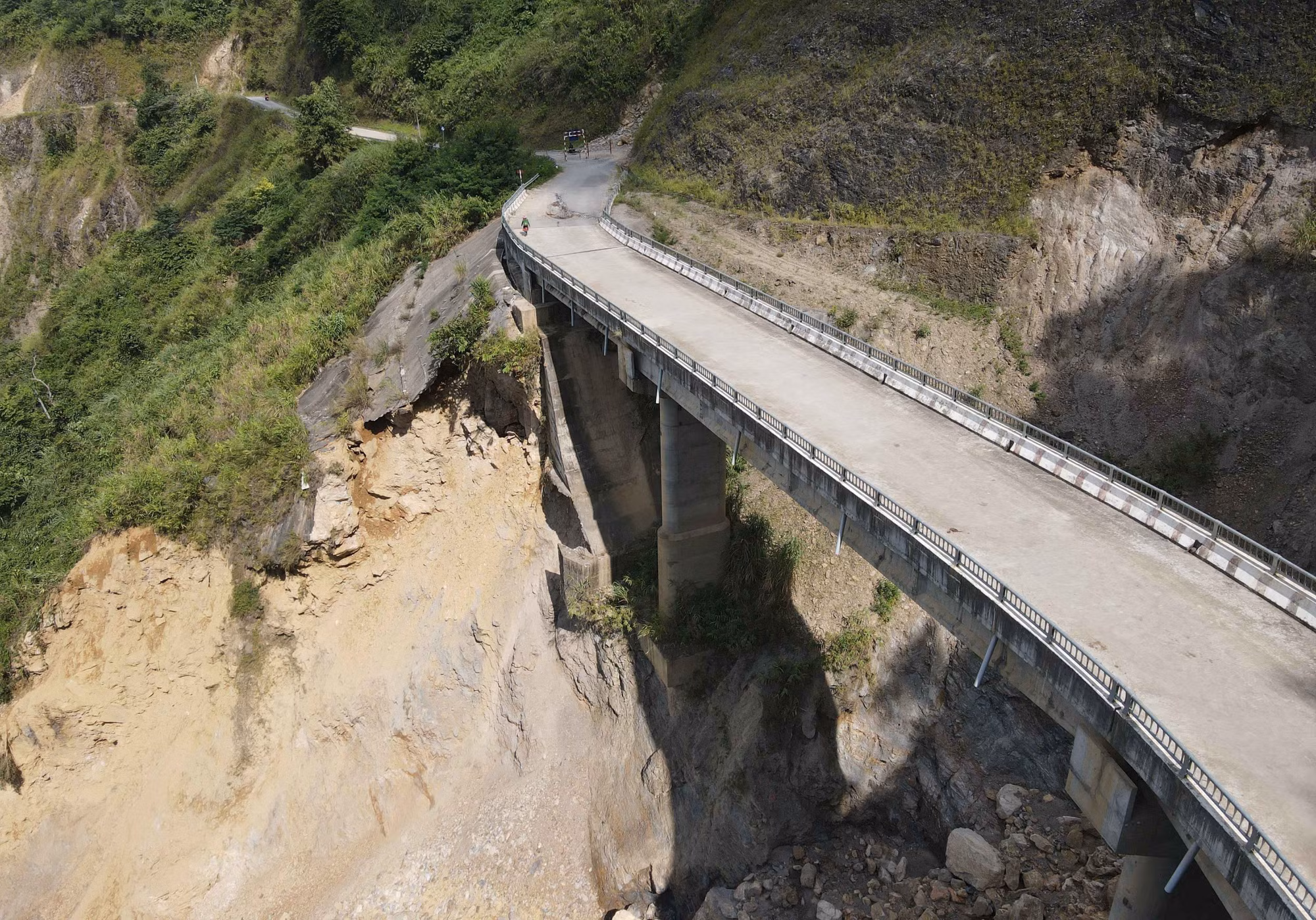 Vệt sạt lở lớn để lộ chân cầu trơ ra.