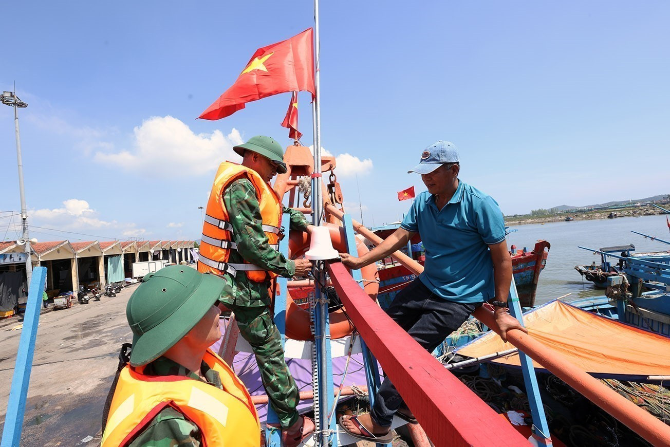 Bộ đội Biên phòng Hải Hoà tặng cờ Tổ quốc cho chủ tàu cá Nguyễn Văn Chiến chuẩn bị ra khơi khai thác thuỷ sản, tại cảng cá Lạch Bạng, phường Hải Bình, tỉnh Thanh Hóa. Bộ đội Biên phòng Hải Hoà tặng cờ Tổ quốc cho chủ tàu cá Nguyễn Văn Chiến chuẩn bị ra khơi khai thác thuỷ sản, tại cảng cá Lạch Bạng, phường Hải Bình, tỉnh Thanh Hóa.