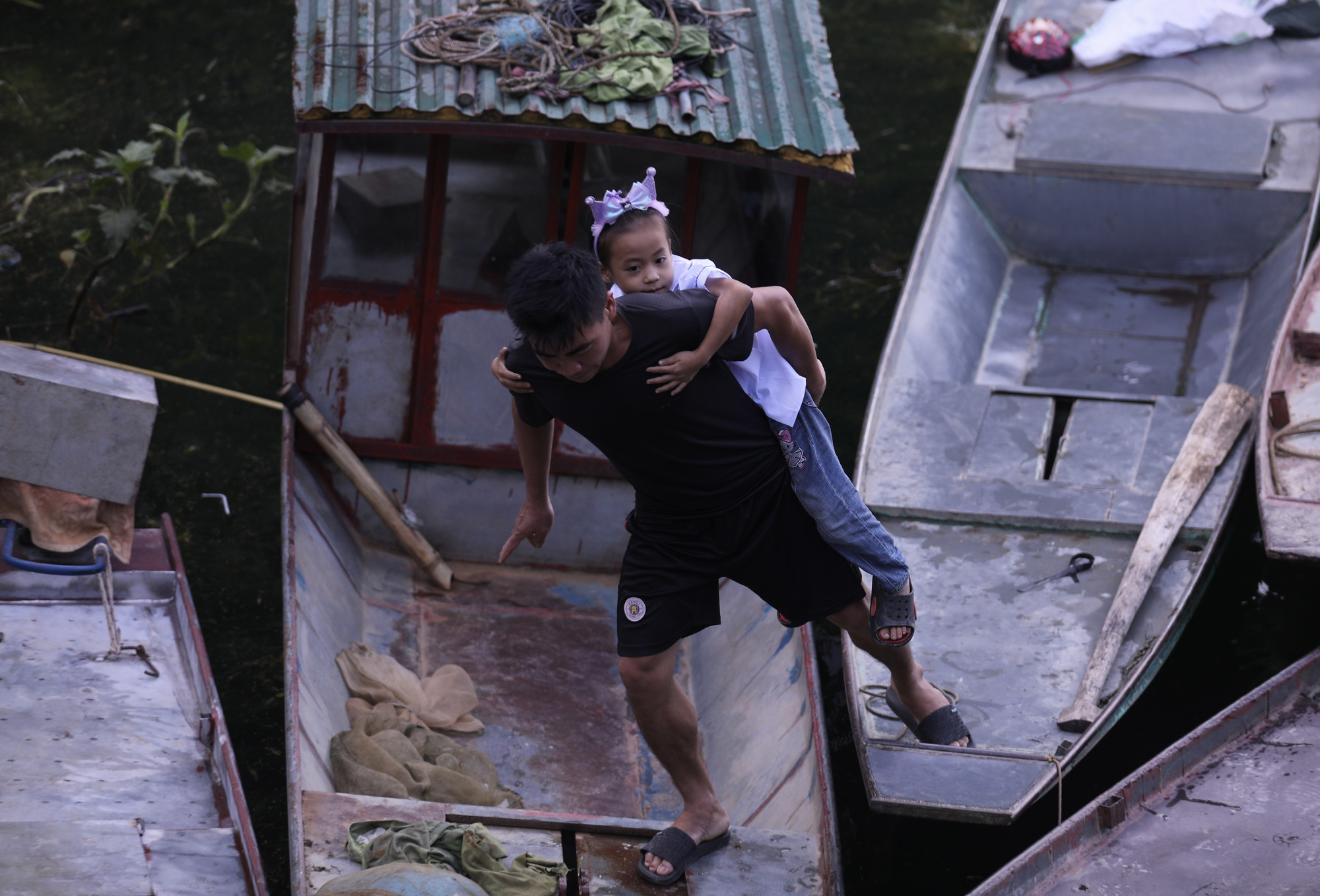 Một phụ huynh cõng con đi qua những con thuyền để kịp dự lễ khai giảng năm học mới tại Trường PTDTBT TH&THCS Vầy Nưa xã Tiền Phong. Một phụ huynh cõng con đi qua những con thuyền để kịp dự lễ khai giảng năm học mới tại Trường PTDTBT TH&THCS Vầy Nưa xã Tiền Phong.