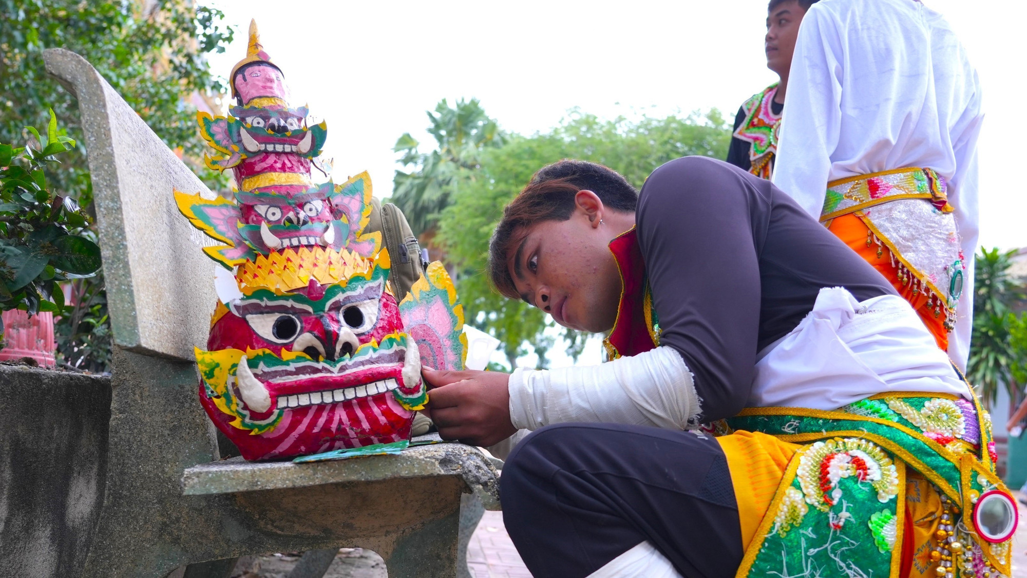 Em Binh Na Quinh, nghệ nhân trẻ Múa Chằn và Múa trống Chhay Dăm chuẩn bị mặt nạ chằng Krông Riêp cho tiết mục biểu diễn. mua-chan-dong-bao-khmer-6.jpg