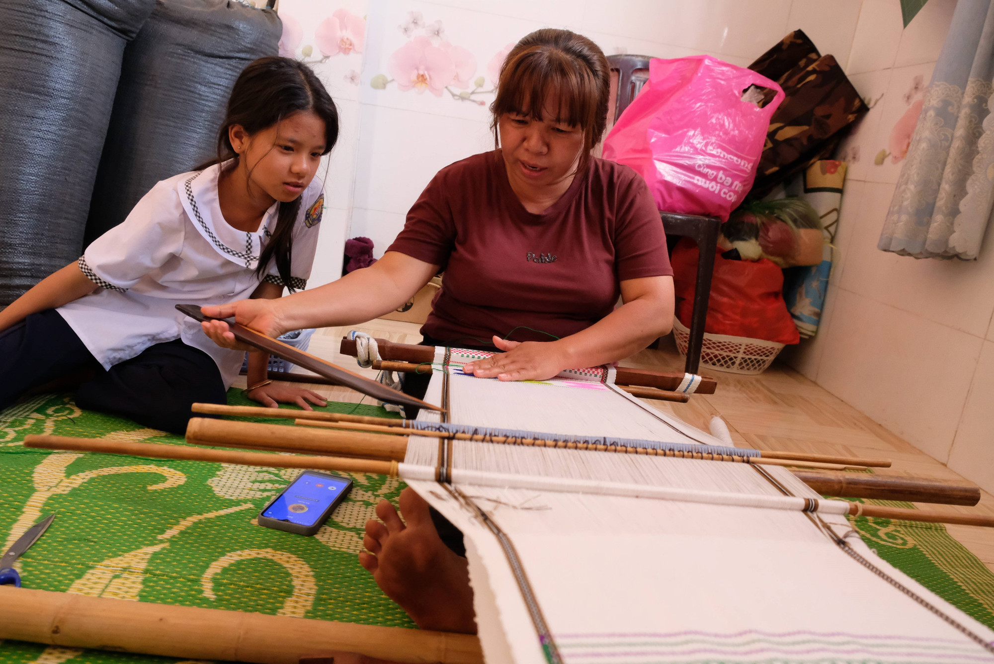 Bà Ka Phép (47 tuổi) truyền dạy cho con gái các kỹ thuật cơ bản của nghề dệt thổ cẩm nhằm giữ gìn nghề truyền thống của dân tộc.