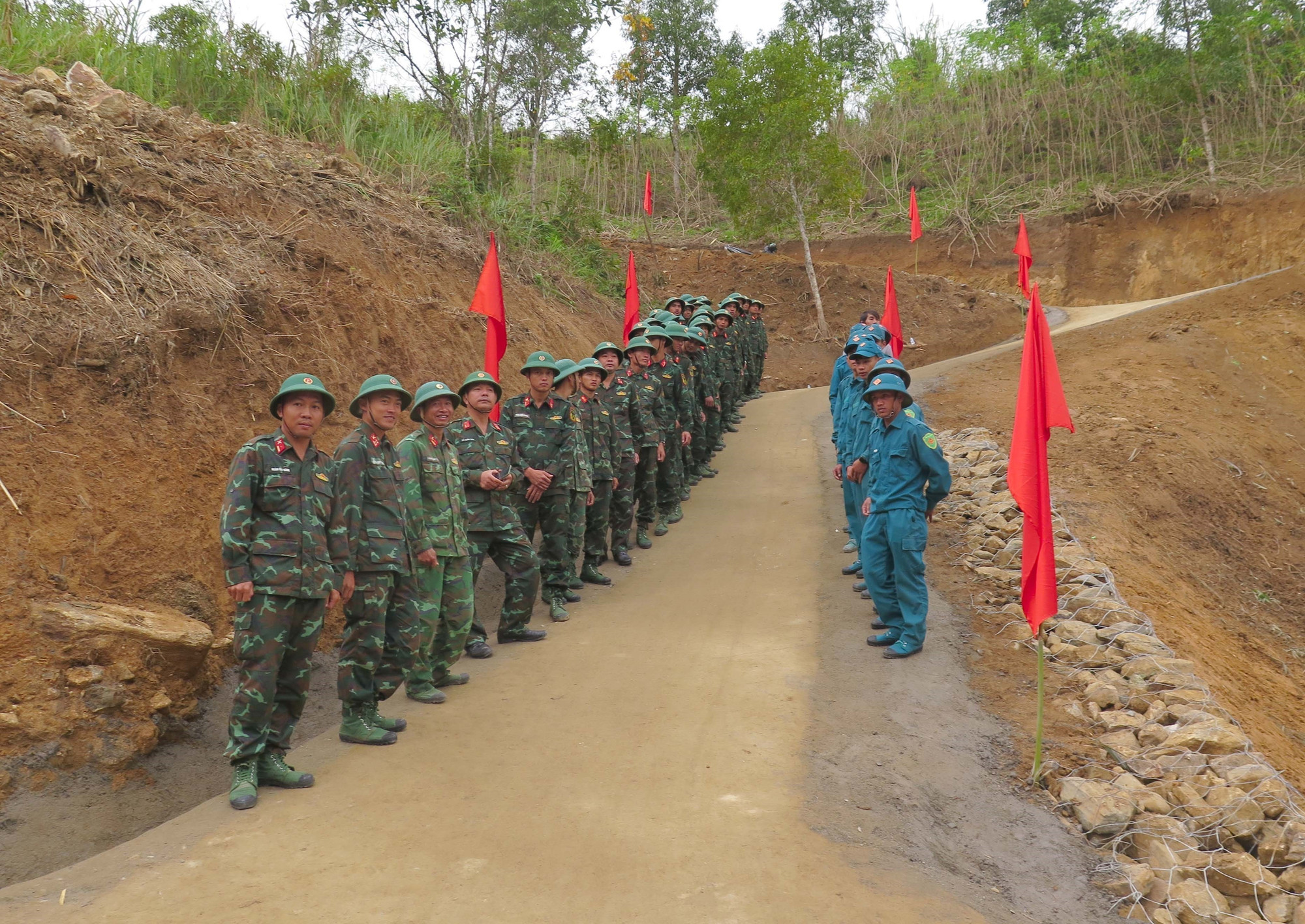 Các cán bộ, chiến sĩ và lực lượng dân quân tự vệ tham gia làm đường tại lễ bàn giao.
