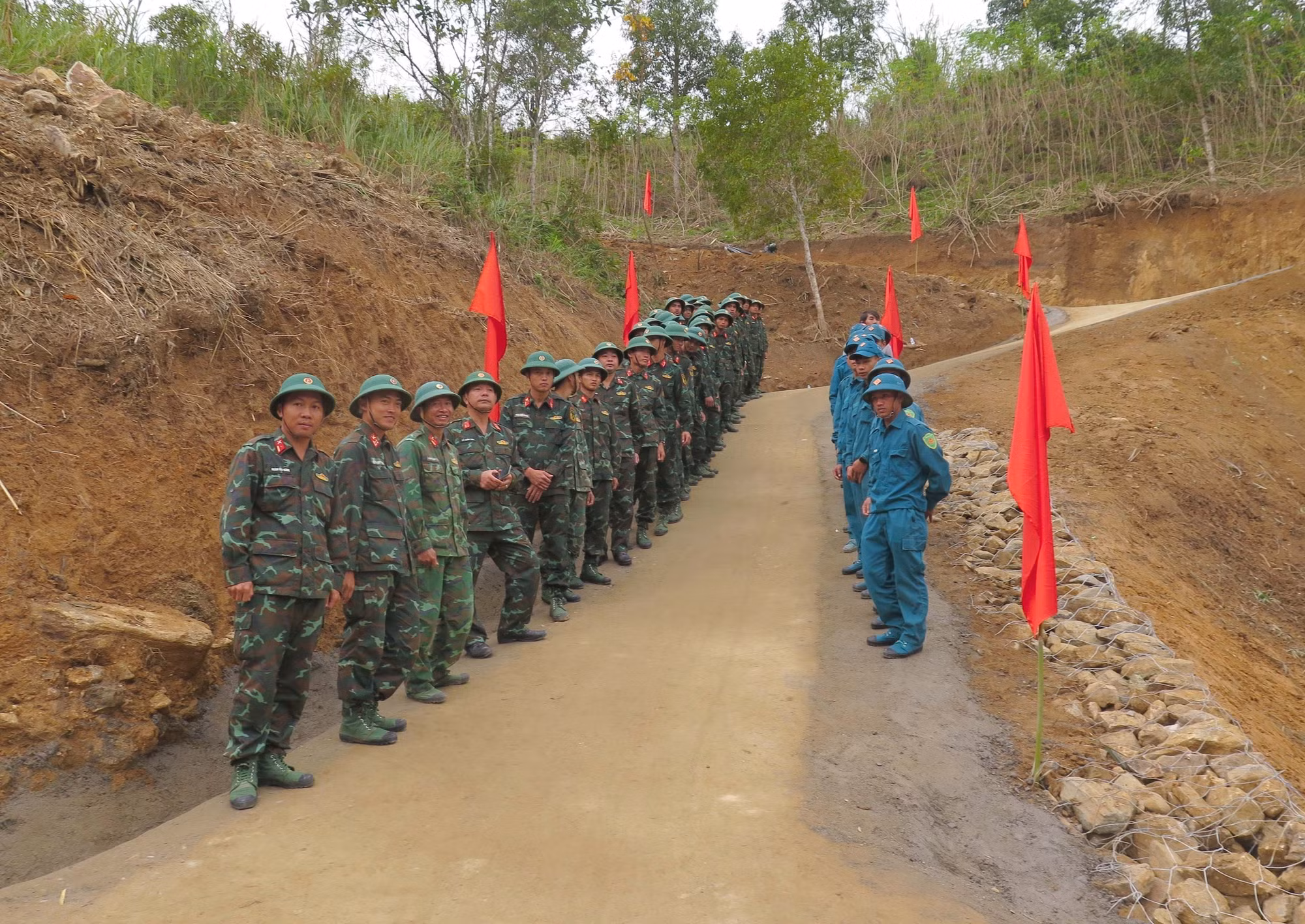 Các cán bộ, chiến sĩ và lực lượng dân quân tự vệ tham gia làm đường tại lễ bàn giao.