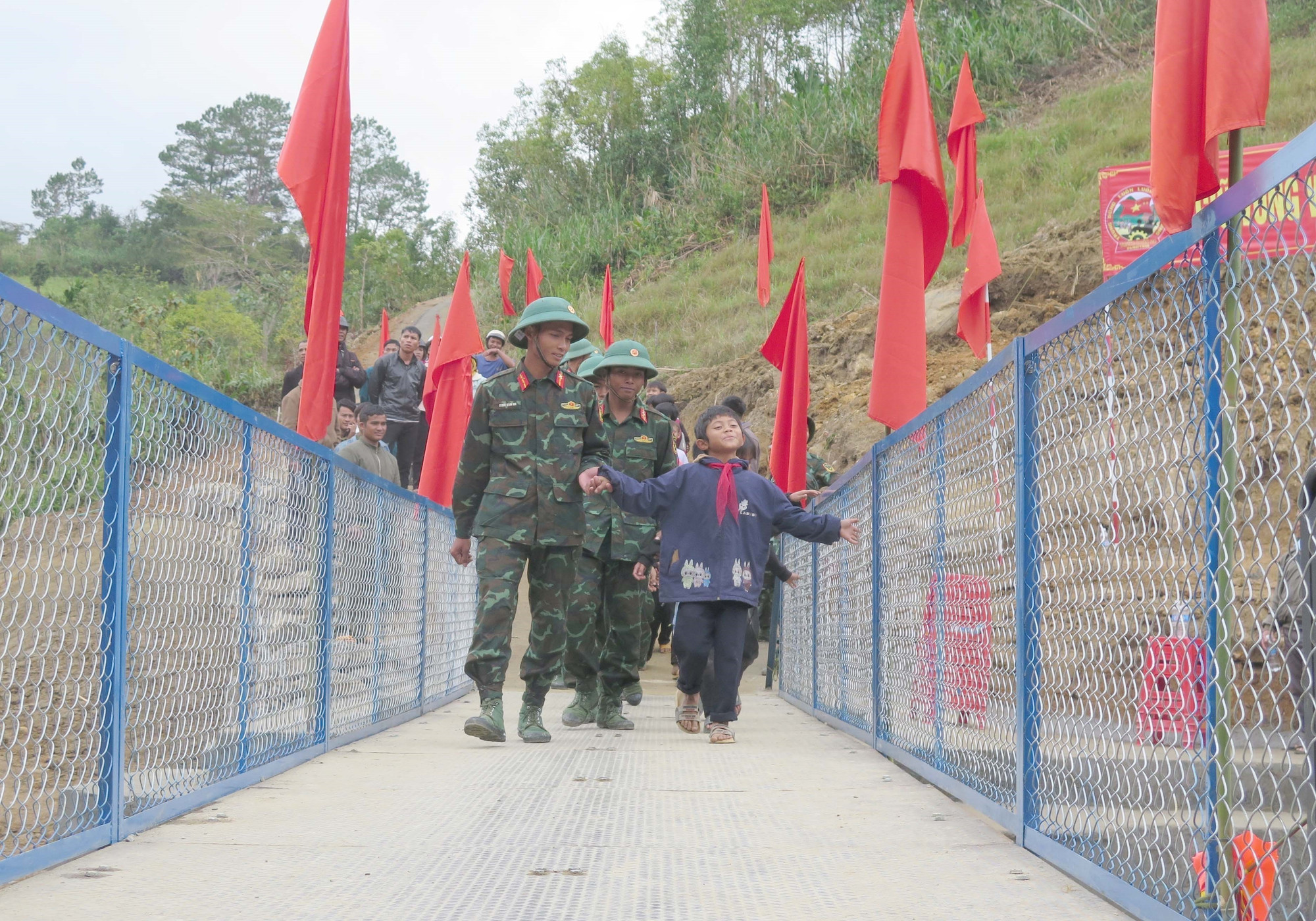 Các cán bộ, chiến sĩ đưa học sinh qua cầu.