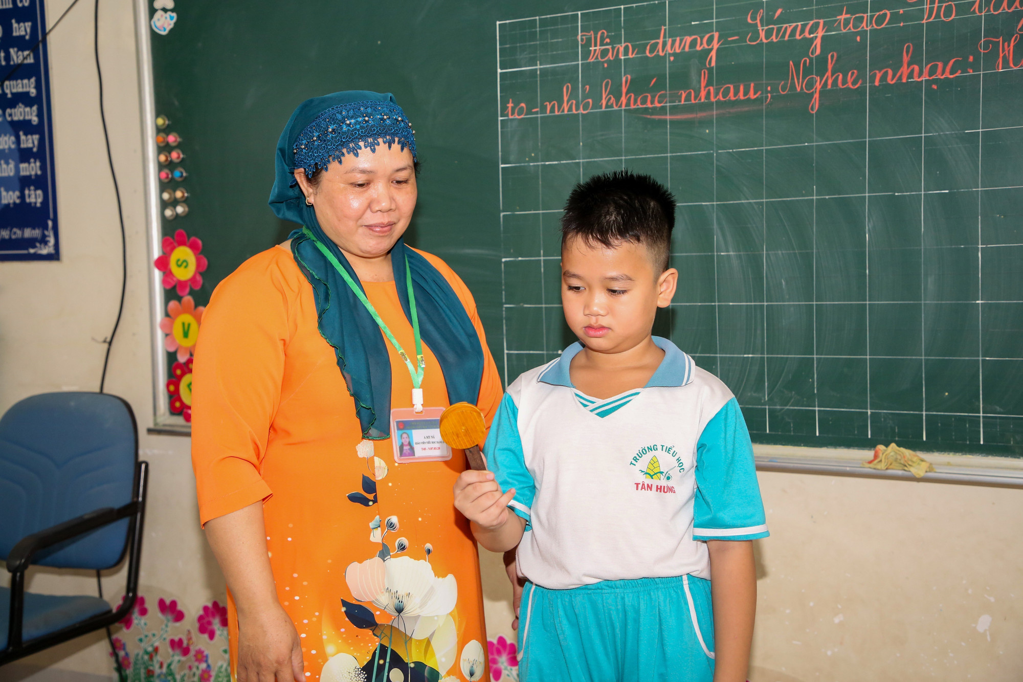 Cô A Mi Ná hướng dẫn học sinh cách sử dụng nhạc cụ dân tộc trong tiết học âm nhạc. Ảnh: Giang Phương/TTXVN