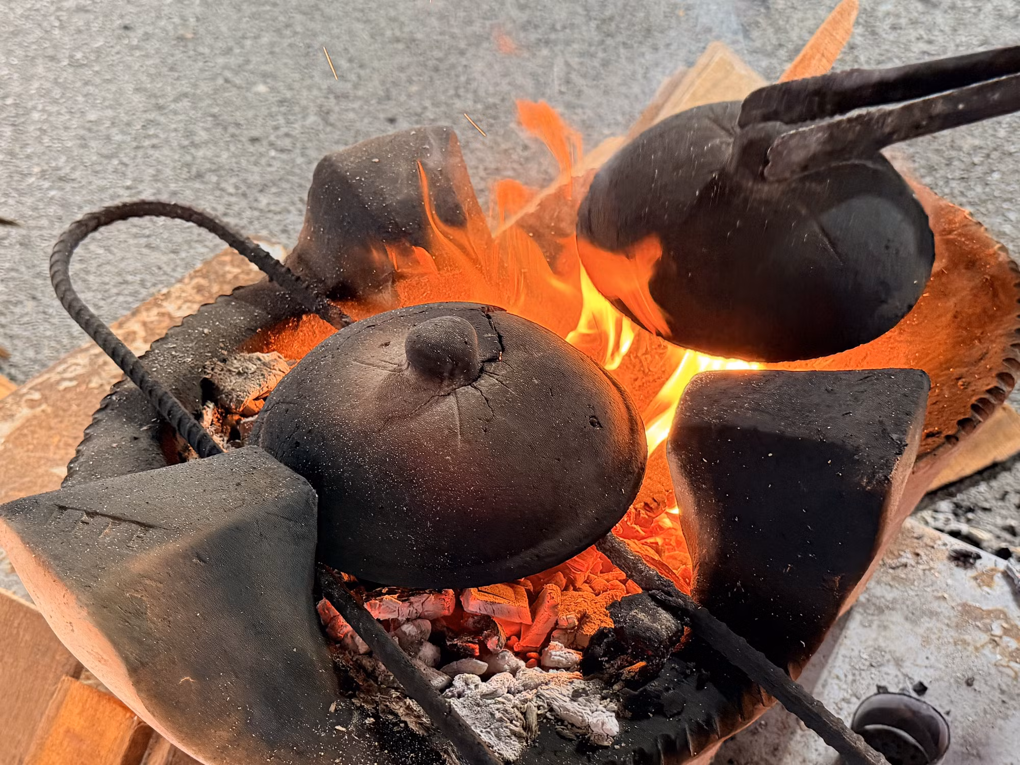 Để mặt bánh chín vàng đều, nghệ nhân hơ nóng nắp chảo trên bếp củi rồi nhanh tay đậy lên.