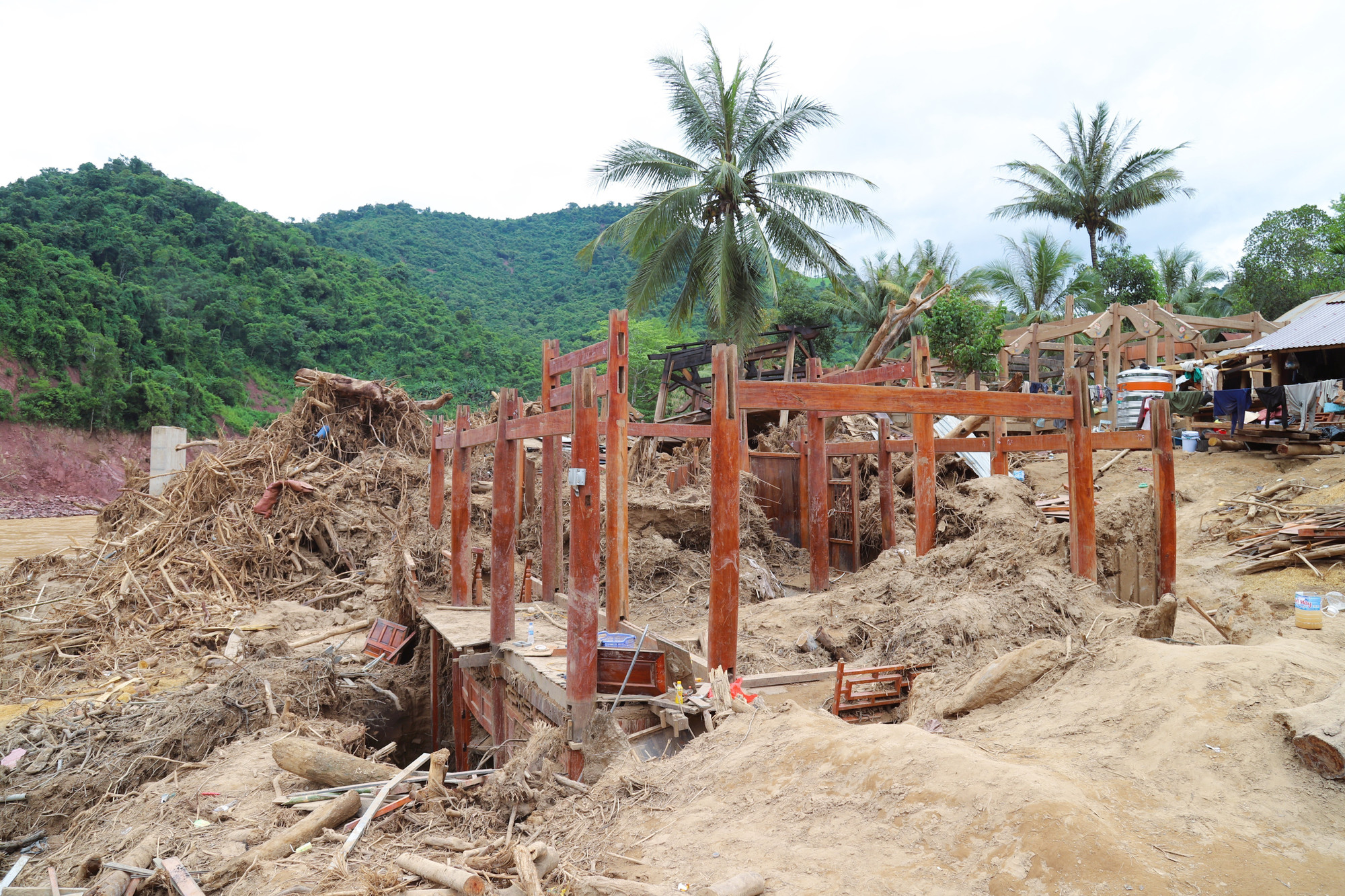 Ngôi nhà sàn bị lũ phá hủy gây thiệt hại nặng nề, chỉ còn trơ khung gỗ. Phần tầng 1 của căn nhà đã bị vùi lấp chìm trong lớp bùn cát sâu hơn 3m. thai-co-yen-hoa-sau-lu-du-13.jpg