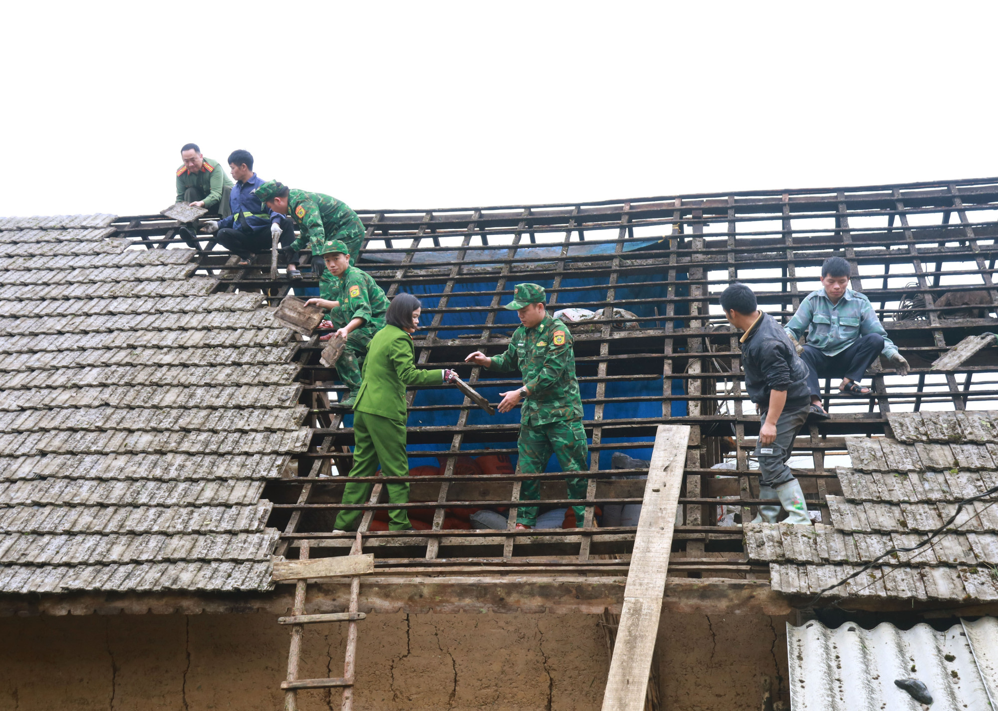 Lực lượng công an, bộ đội biên phòng Tùng Vài (Tuyên Quang) giúp người dân lợp lại mái nhà.