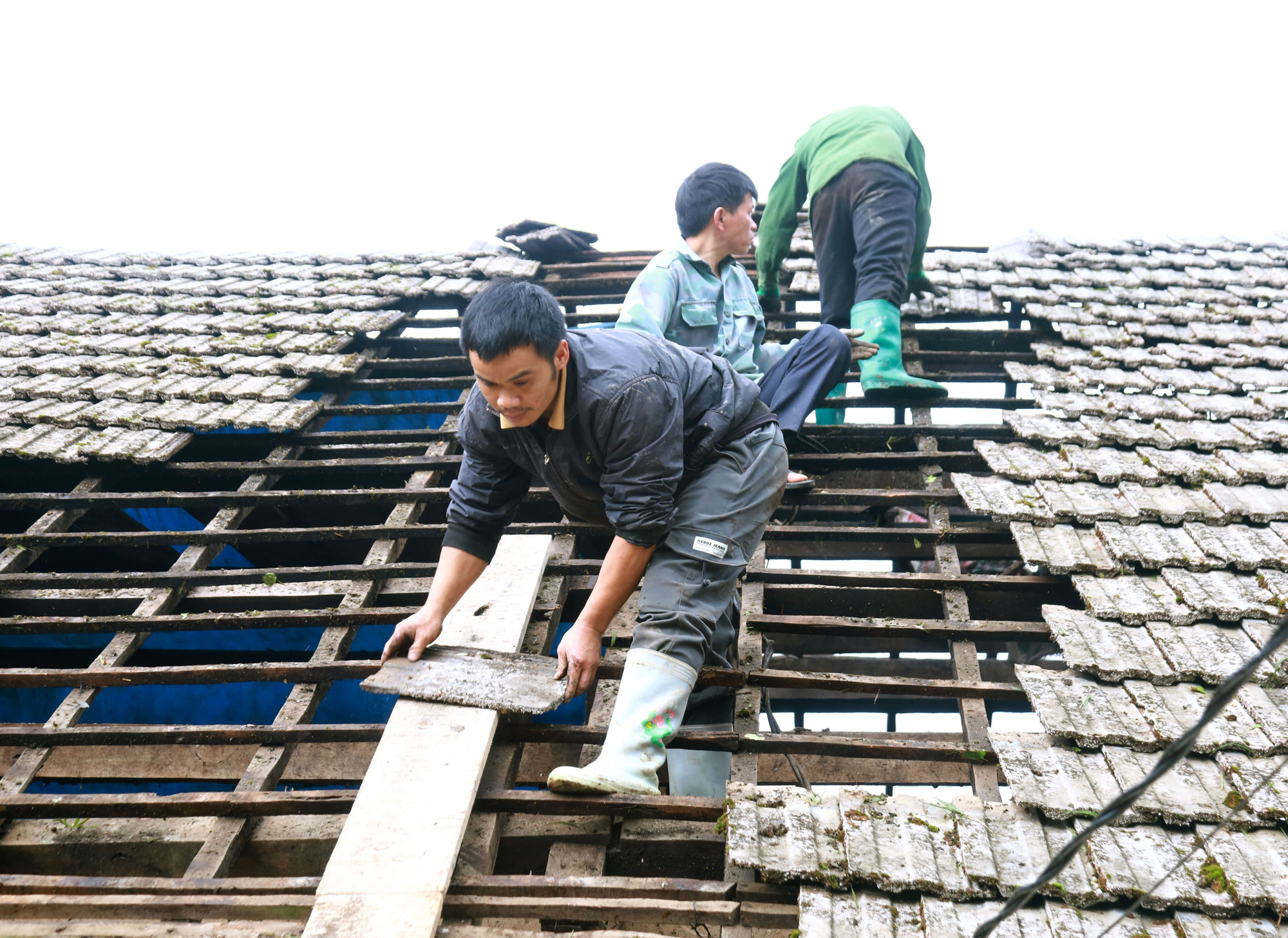 Người dân xã biên giới Tùng Vài (Tuyên Quang) cùng chung tay lợp lại mái nhà bị hư hỏng.