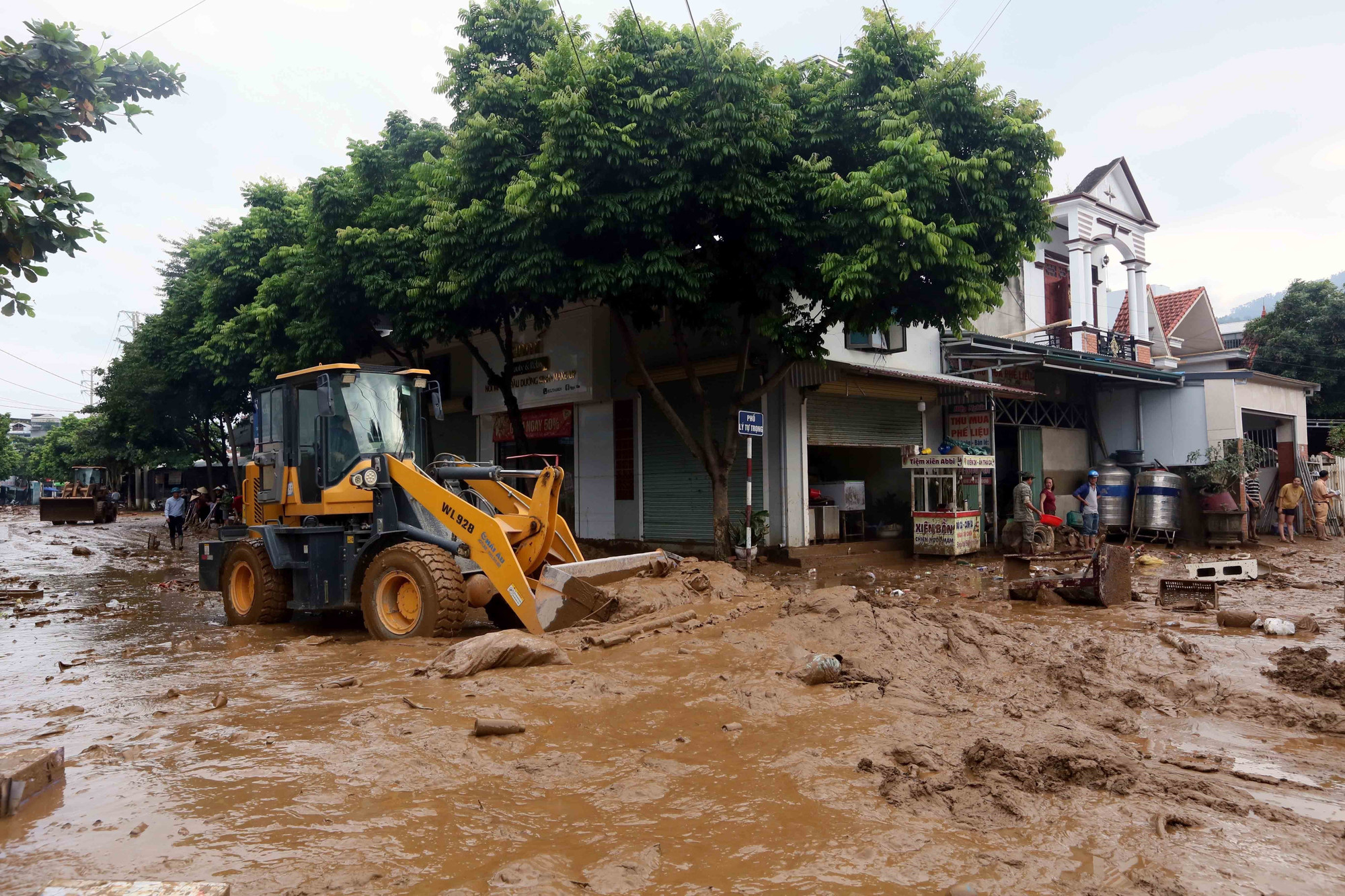 Máy xúc được huy động để hỗ trợ san gạt, thu gom bùn đất, cành cây, rác bị tràn về trong đợt lũ vừa qua tại xã Sông Mã. thien-tai-song-ma-son-la-1.jpg