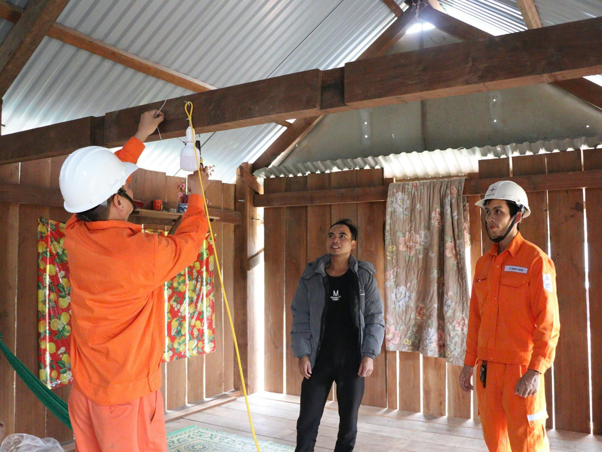 Công nhân lắp đặt bóng đèn và bảng điện mới trong các hộ gia đình vùng miền núi Quảng Trị. Ảnh: TTXVN phát