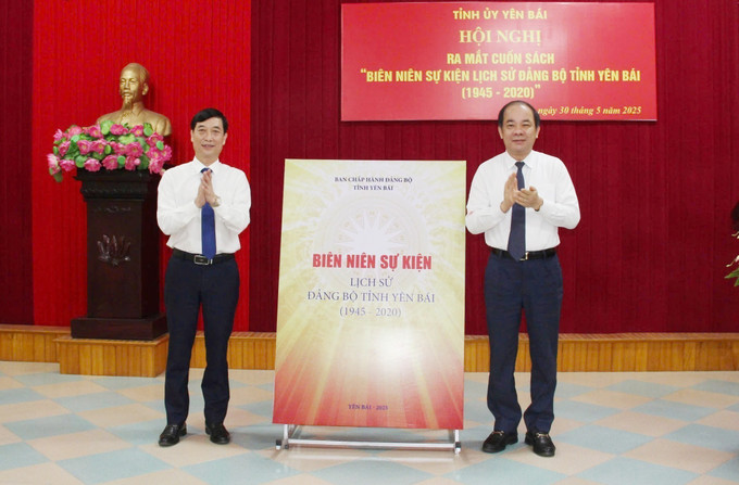 Phó Bí thư Thường trực Tỉnh ủy, Chủ tịch HĐND tỉnh Yên Bái Tạ Văn Long (phải) và Trưởng Ban Tuyên giáo và Dân vận Tỉnh ủy Yên Bái Nguyễn Minh Tuấn thực hiện nghi thức ra mắt cuốn sách. Ảnh: TTXVN phát yen-bai-30525-15.jpg