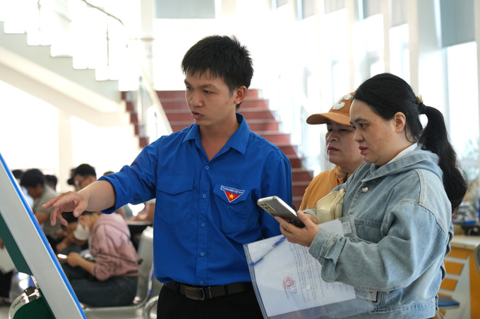 Đoàn viên thanh niên hướng dẫn người dân lấy số thứ tự khi đến giải quyết thủ tục hành chính. quang-ngai-12725-10.jpg