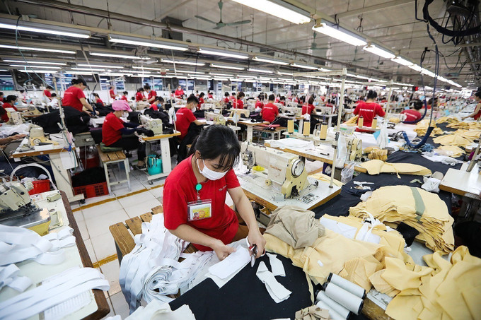 Công nhân làm việc tại xưởng sản xuất hàng may mặc xuất khẩu của Công ty TNHH Seyoung Inc (100% vốn đầu tư của Hàn Quốc) tại Khu công nghiệp Lương Sơn (Hòa Bình). Ảnh: Trọng Đạt/TTXVN hoa-binh-19625-11.jpg
