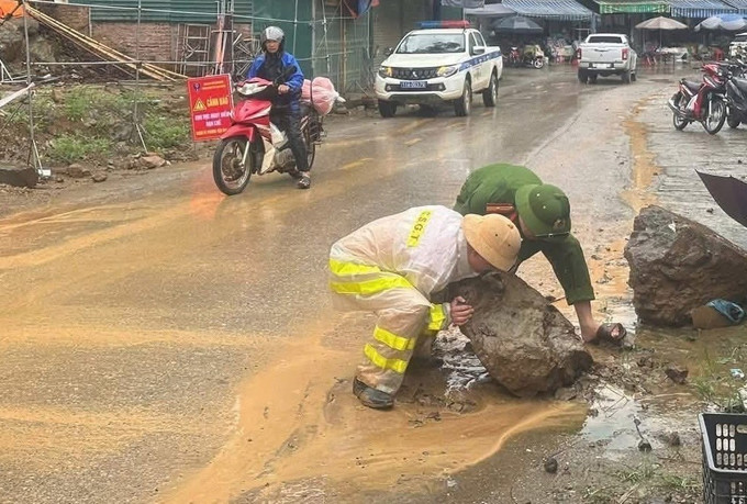 Cảnh sát giao thông huyện Bảo Lạc khắc phục hiện tượng sạt lở đất đá do mưa lớn, tạo thuận lợi cho người tham gia lưu thông. Ảnh: TTXVN phát cao-bang-23625-21.jpg