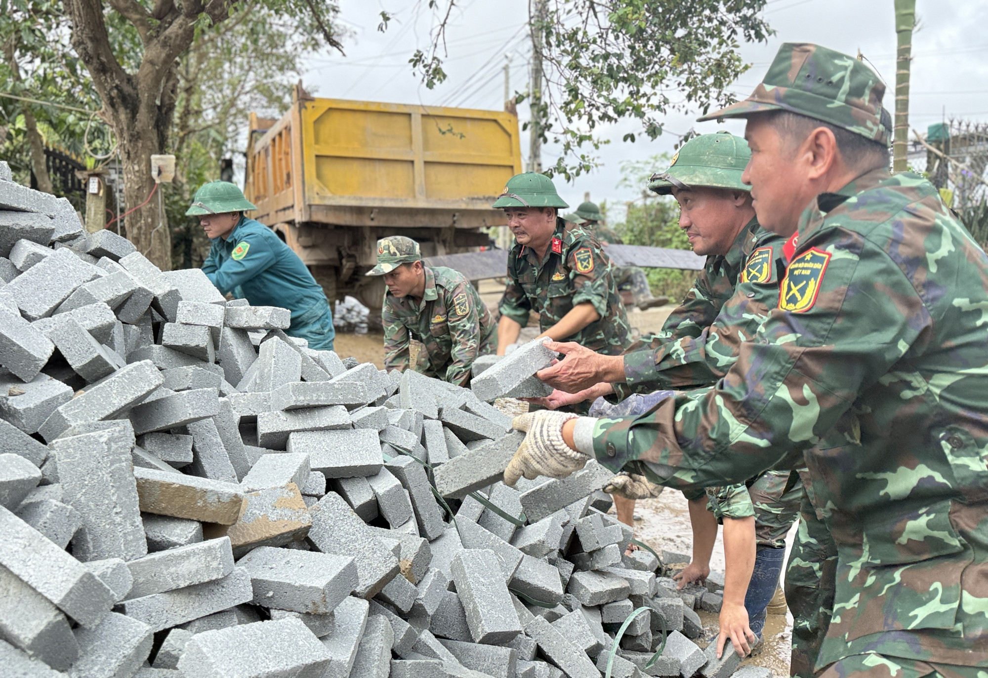 Chiến sỹ Đoàn Kinh tế - Quốc phòng 207/Quân khu 5 vận chuyển vật liệu xây sửa nhà cho người dân.