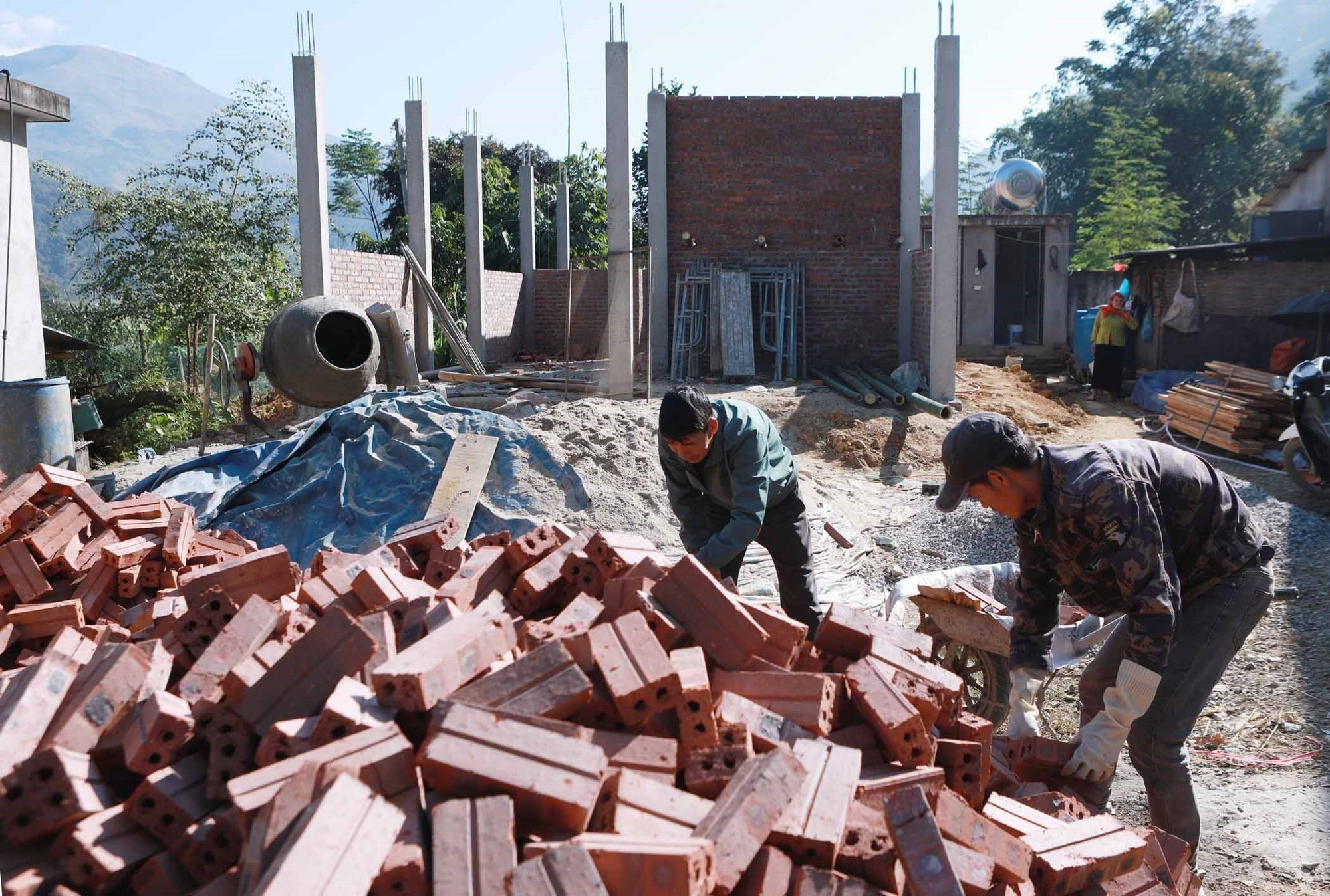Người dân ở bản Nà Cùng, xã Phong Thổ, cùng nhau hỗ trợ giúp ngày công để xây dựng những ngôi nhà mới thay cho những ngôi nhà tạm, nhà dột nát.