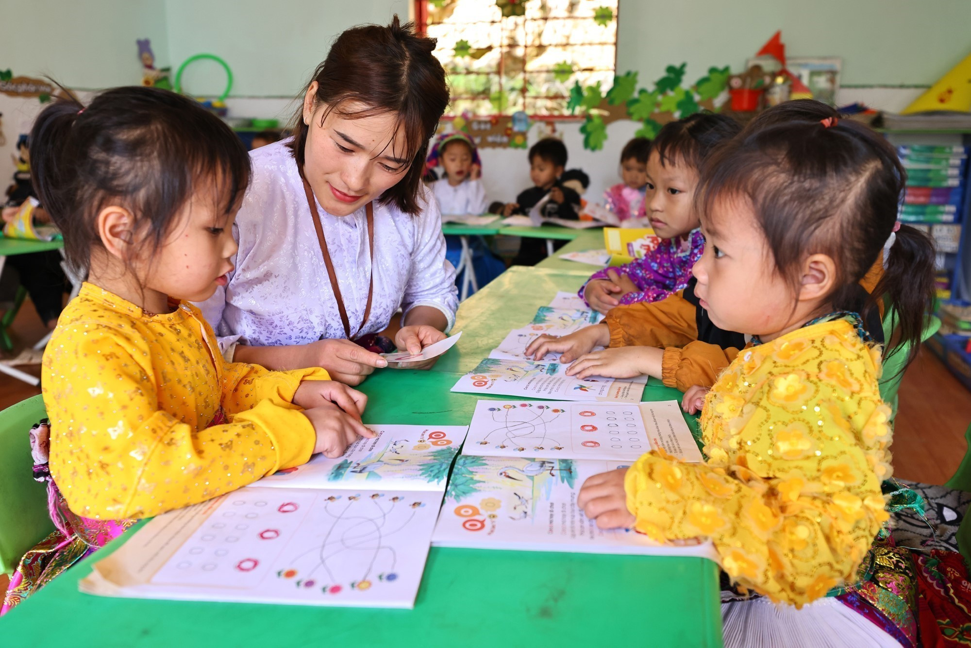 Giáo viên, đảng viên Vàng Thị Tro trong một buổi dạy lớp ghép 4 và 5 tuổi tại điểm trường Tràng Hương, xã Mèo Vạc.