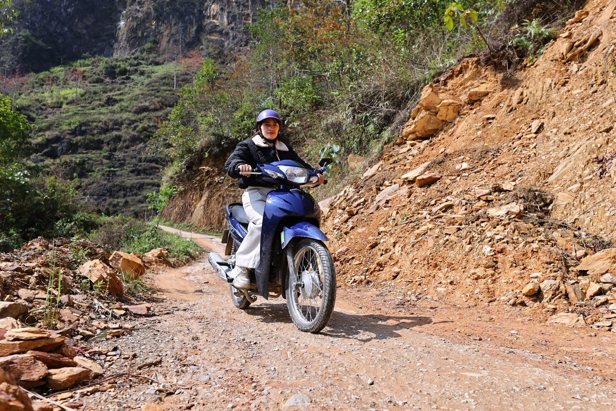 Để tới được điểm trường trong điều kiện giao thông vùng cao nhiều khó khăn, cô giáo Vàng Thị Tro phải di chuyển trên những con đường chênh vênh bên sườn núi.