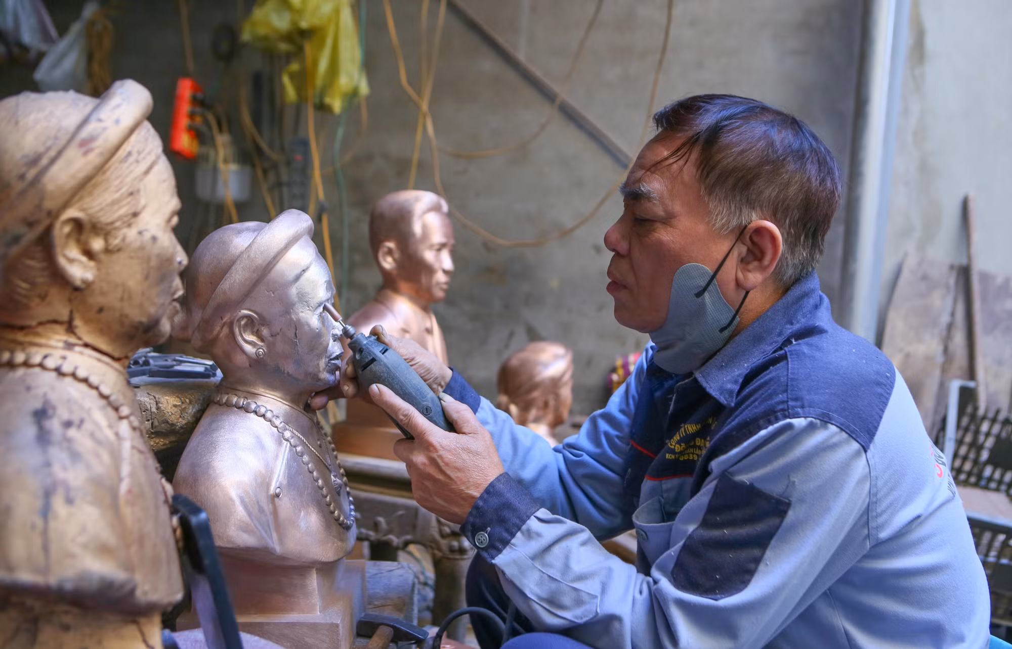 Nghệ nhân Dương Xuân Tuyên ở àng Vạn Điểm (Ninh Bình) đánh bóng bức tượng truyền thần.