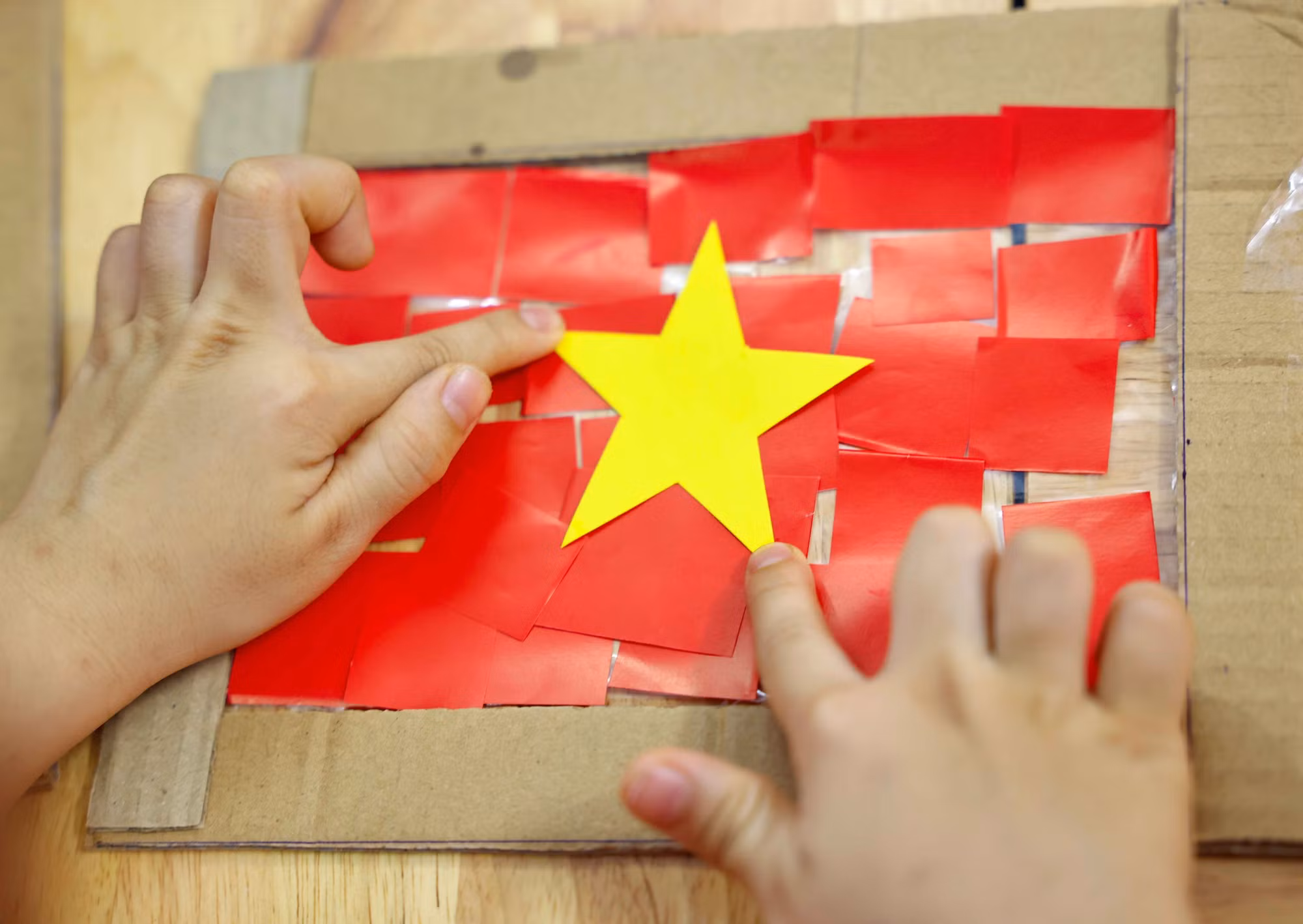 Chỉ bằng những nguyên vật liệu đơn giản, với keo dán trẻ đã tạo ra lá cờ Tổ quốc xinh xắn.