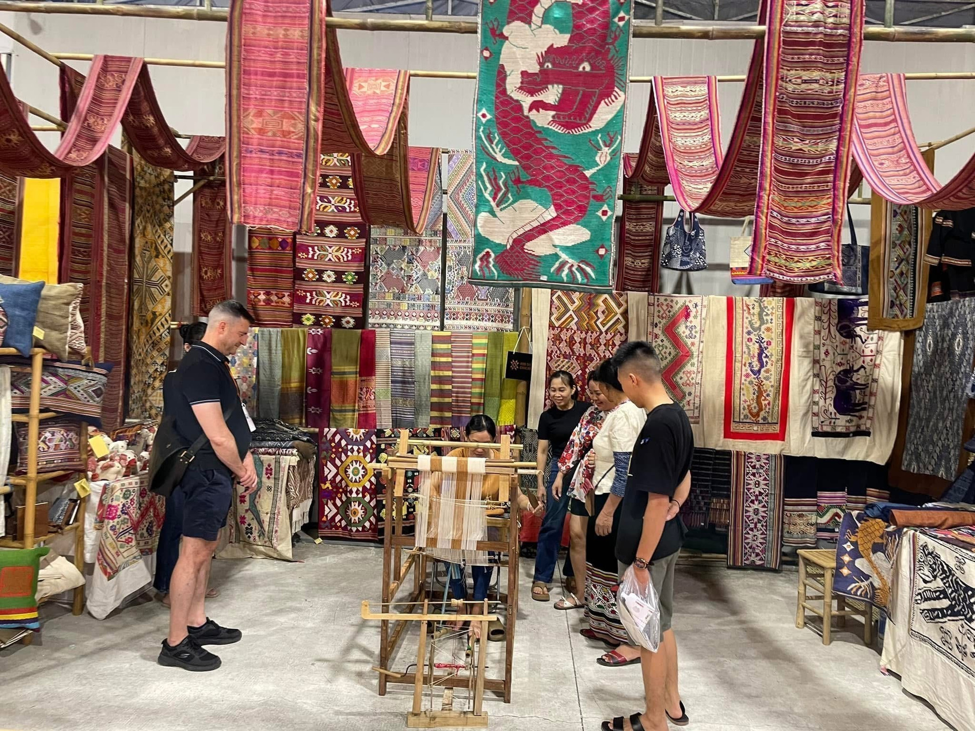 Du khách tham quan, mua sắm các sản phẩm dệt thổ cẩm Hoa Tien Brocade. Ảnh: TTXVN phát tho-cam-dan-toc-thai-11062025-07.jpg