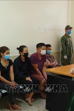 Cán bộ Biên phòng lấy lời khai các đối tượng nhập cảnh trái phép. Ảnh: Quang Duy - TTXVN