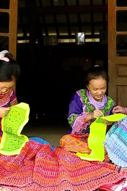 Bà Cù Thị Triệu, thôn Khuổi Khít, xã Kiến Thiết (huyện Yên Sơn, tỉnh Tuyên Quang) dạy các cháu gái kỹ thuật thêu hoa văn trên trang phục truyền thống. Ảnh: Vũ Quang – TTXVN 