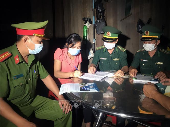 Lực lượng Đồn Biên phòng Hồ Le và Công an xã Ia Dal, huyện Ia H’Drai (Kom Tum) tuyên truyền, vận động người dân ký cam kết thực hiện các biện pháp phòng dịch COVID-19 và xuất, nhập cảnh trái phép. Ảnh: Khoa Chương - TTXVN