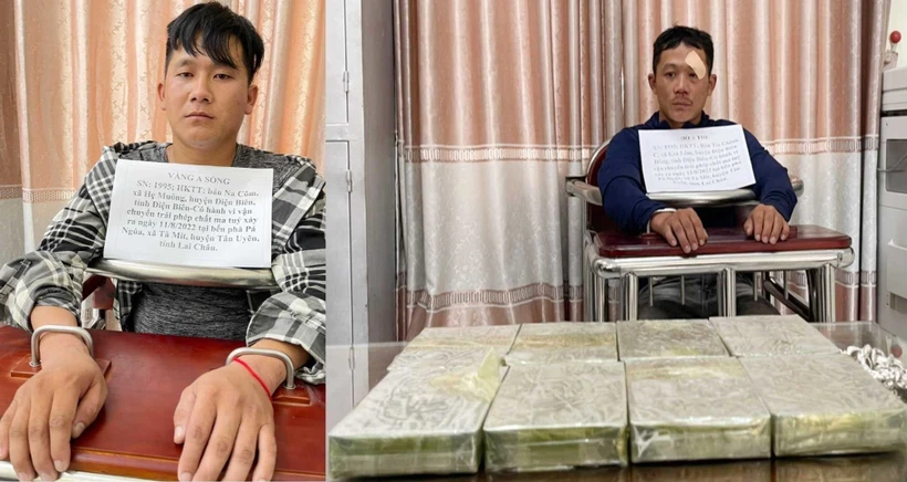 Hai đối tượng Vàng A Sồng (trái) và Hờ A Thu cùng 8 bánh heroin tại cơ quan điều tra. Ảnh: TTXVN