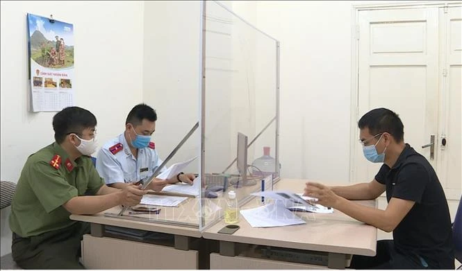 Lực lượng chức năng làm việc với anh Trần Văn Duy. Ảnh: TTXVN