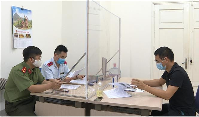 Lực lượng chức năng làm việc với anh Trần Văn Duy. Ảnh: TTXVN