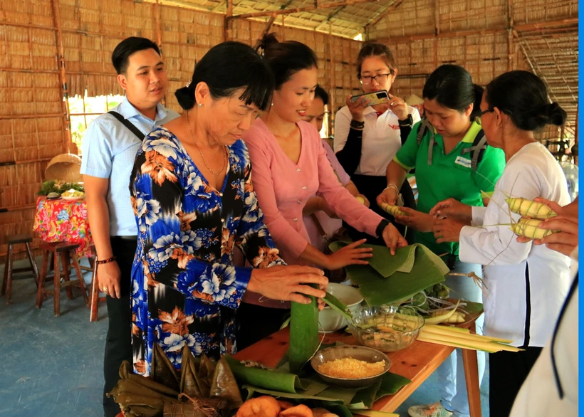 Du khách trải nghiệm hoạt động làm bánh dân gian tại Miss Hai Homestay, huyện Tam Bình, tỉnh Vĩnh Long. Ảnh: Lê Thúy Hằng - TTXVN