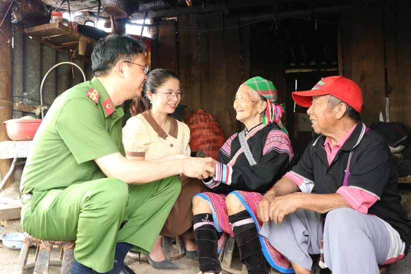 Thượng tá Hà Thái Hoàn, Trưởng Công an thành phố Lai Châu và lãnh đạo xã Sùng Phài chia sẻ khó khăn của vợ chồng ông Giàng A Súa khi phải ở trong lều tre. Ảnh: Đinh Thùy - TTXVN 