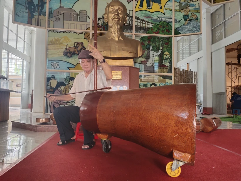 Nghệ nhân Võ Văn Bá sử dụng nhạc cụ đờn cò làm từ gốc dừa lớn nhất Việt Nam. Ảnh: Huỳnh Phúc Hậu - TTXVN