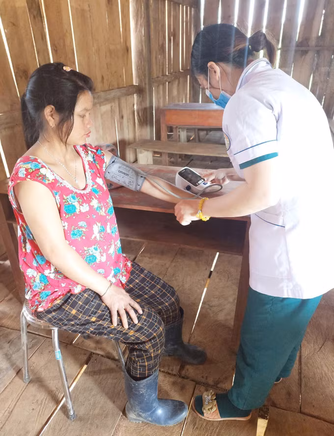 Cán bộ y tế tại Trạm Y tế xã Măng Cành, huyện Kon Plông (Kon Tum) trực tiếp đến nhà khám bệnh cho người dân. Ảnh: Dư Toán – TTXVN