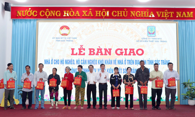 Tặng quà cho các hộ nghèo tại Lễ bàn giao. Ảnh: Trung Hiếu - TTXVN potal-soc-trang-ban-giao-120-can-nha-cho-ho-ngheo-truoc-them-nam-moi-7773524.jpg