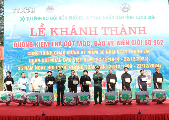 Thủ trưởng Bộ tư lệnh BĐBP tặng quà cho các hộ gia đình có nhiều thành tích tham gia thực hiện xây dựng đường kiểm tra cột mốc, bảo vệ biên giới số 962, tỉnh Lạng Sơn. Ảnh: Quang Duy – TTXVN vna_potal_khanh_thanh_duong_kiem_tra_cot_moc_bao_ve_bien_gioi_lang_son_7717529.jpg