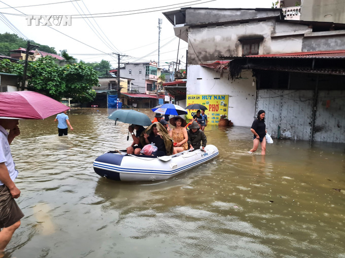 Cán bộ, chiến sĩ Công an tỉnh Hà Giang hỗ trợ di chuyển người và tài sản bị ngập sâu trong nước. Ảnh: Nguyễn Lân/TTXVN phát vna_potal_ha_giang_mua_lu_khien_2_nguoi_chet_thiet_hai_ban_dau_uoc_tinh_gan_10_ty_dong_7422796 (1).jpg