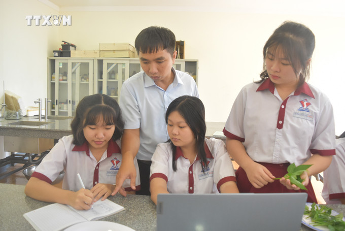 Giáo viên Trường THCS & THPT Đông Du (thành phố Buôn Ma Thuột) hướng dẫn học sinh học tập. Ảnh: Nguyên Dung – TTXVN vna_potal_giao_duc_mui_nhon_dak_lak_no_luc_thu_“qua_ngot”_anh_trong_bai_7389561.jpg