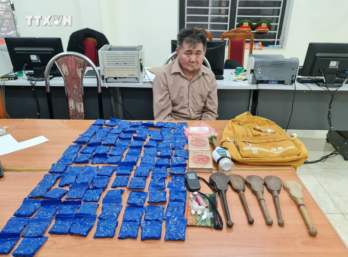 Đối tượng Hờ Bả Tủa cùng tang vật tại cơ quan Công an. Ảnh: TTXVN phát. vna_potal_cong_an_son_la_bat_doi_tuong_mua_ban_trai_phep_chat_ma_tuy_so_luong_lon_7237431.jpg