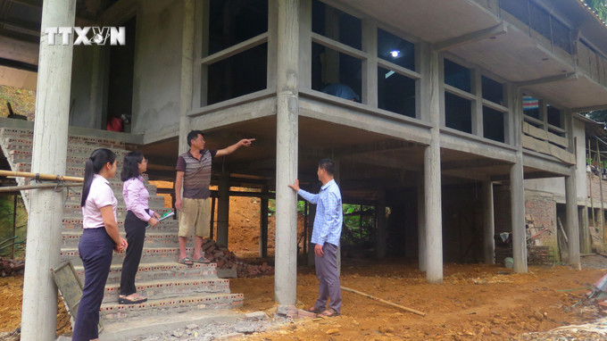 Ngôi nhà sàn bằng bê tông dần hoàn thiện của gia đình ông Quang Văn Lường (thứ 2 từ phải qua), dân tộc Tày, thôn On Cáy, xã Tân Mỹ, huyện Chiêm Hóa, tỉnh Tuyên Quang. Ảnh: Hoàng Hải - TTXVN vna_potal_tuyen_quang_cham_lo_doi_song_dong_bao_dan_toc_thieu_so_7517057.jpg