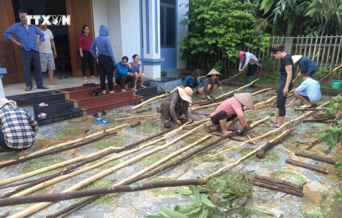 UBND xã Đại Sơn huy động lực lượng dân quân và người dân khắc phục tạm thời hậu quả thiên tai, thu dọn nhà cửa, di chuyển đồ đạc của hộ gia đình bị sập do sạt lở taluy. Ảnh: TTXVN phát vna_potal_1_can_nha_bi_sap_va_17_ho_dan_bi_co_lap_do_mua_lon_tai_yen_bai_7490767.jpg
