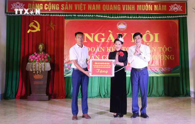 Phó Trưởng Ban Nội chính Trung ương Nguyễn Hữu Đông tặng quà cho đại diện Ban Công tác Mặt trận bản Cang Mường. Ảnh: Quang Quyết - TTXVN vna_potal_pho_truong_ban_noi_chinh_trung_uong_nguyen_huu_dong_du_ngay_hoi_dai_doan_ket_toan_dan_toc_tai_son_la_7708540.jpg