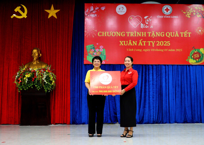 Đại diện Quỹ Thiện Tâm (Tập đoàn Vingroup) trao bảng tượng trưng kinh phí hỗ trợ 1.500 phần quà Tết cho người nghèo tỉnh Vĩnh Long. Ảnh: Lê Thúy Hằng-TTXVN potal-vinh-long-trao-1500-phan-qua-cho-nguoi-ngheo-don-tet-7798093.jpg