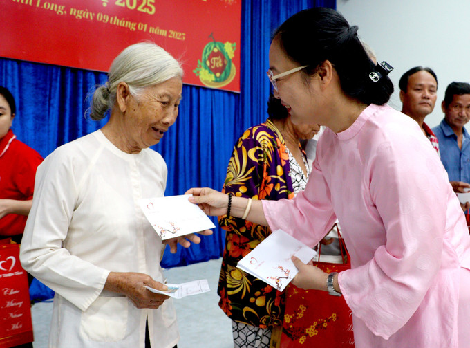 Phó Chủ tịch UBND tỉnh Vĩnh Long Nguyễn Thị Quyên Thanh trao quà Tết cho các hộ dân. Ảnh: Lê Thúy Hằng-TTXVN potal-vinh-long-trao-1500-phan-qua-cho-nguoi-ngheo-don-tet-7798092.jpg