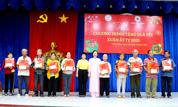 Trao quà Tết cho các hộ dân. Ảnh: Lê Thúy Hằng-TTXVN potal-vinh-long-trao-1500-phan-qua-cho-nguoi-ngheo-don-tet-7798096.jpg